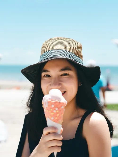 A woman with an ice cream on the beachfront on a summer afternoon
