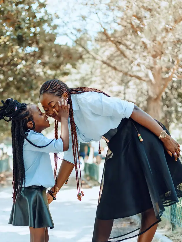 A mother and her daughter laughing together outdoors